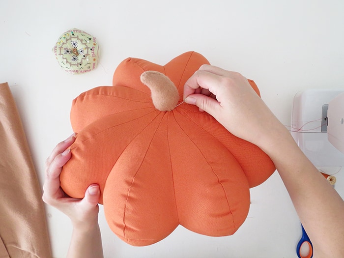 sew the stem on the pumpkin shaped pillow