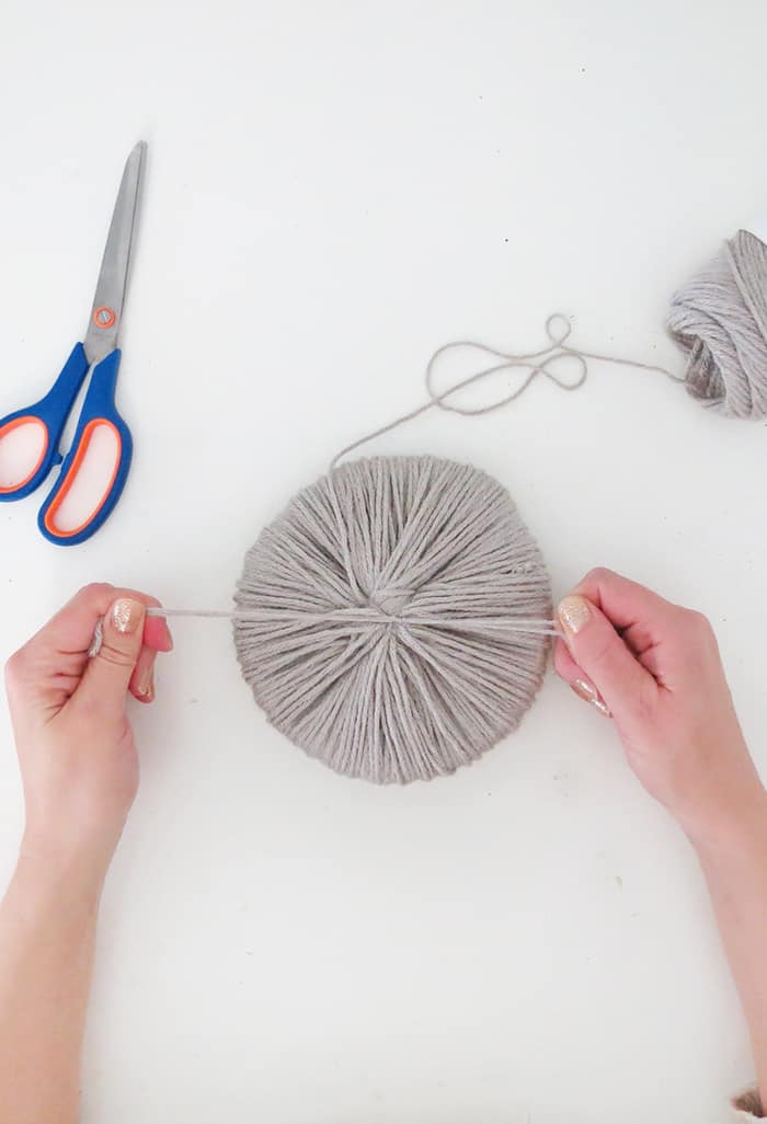 tie a knot to hold giant pom pom together