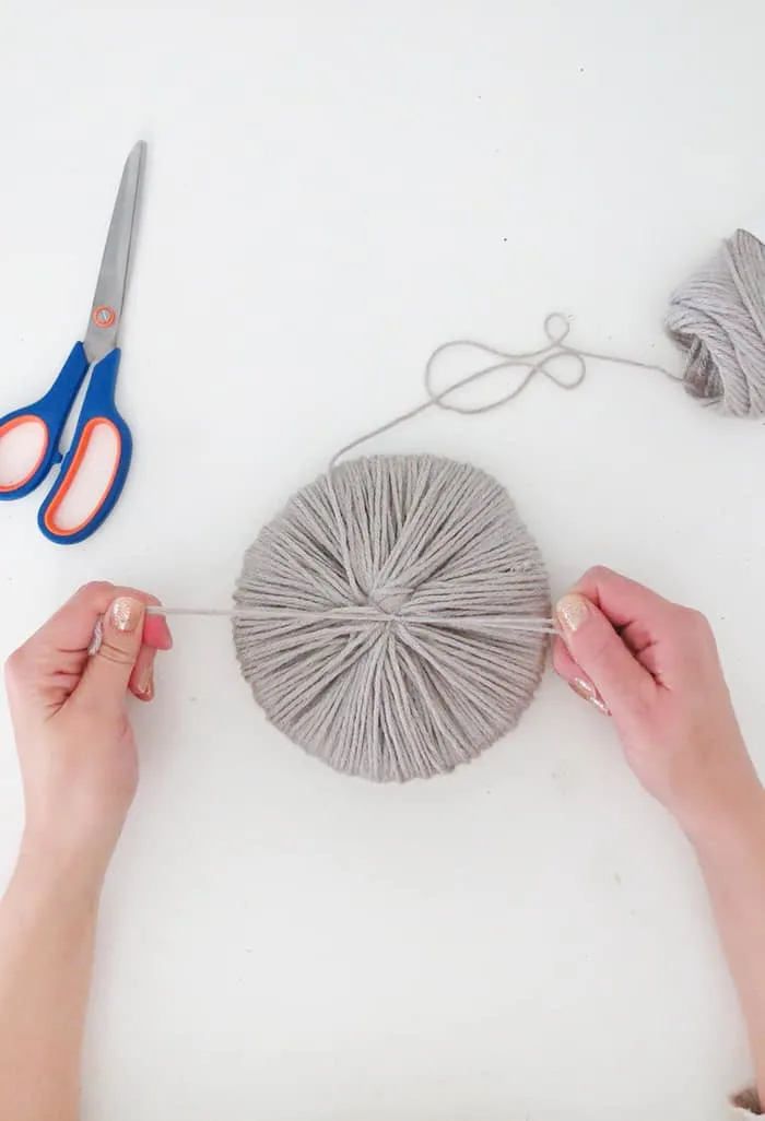 tie a knot to hold giant pom pom together