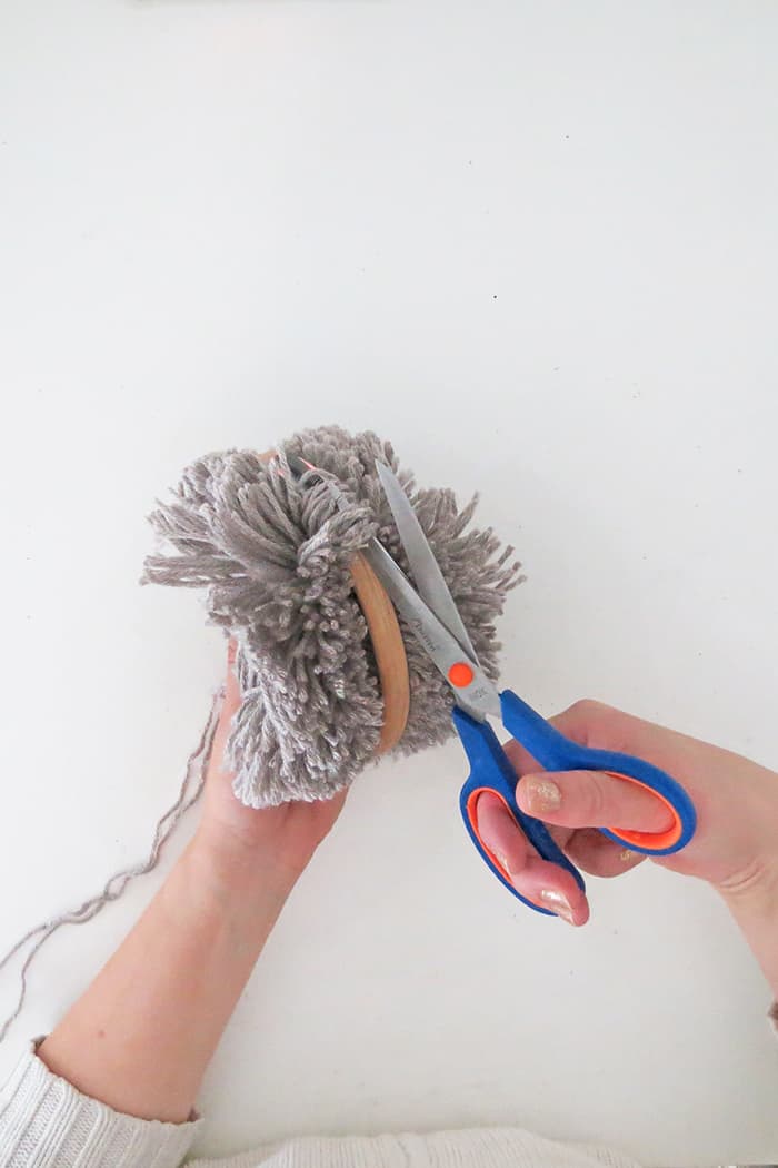 Cut around the hoop to make large yarn pom pom