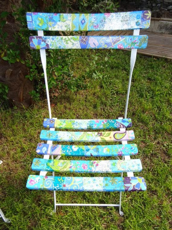 This may contain: a blue and white chair sitting in the grass