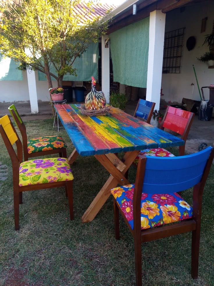 This may contain: a wooden table with colorful chairs around it